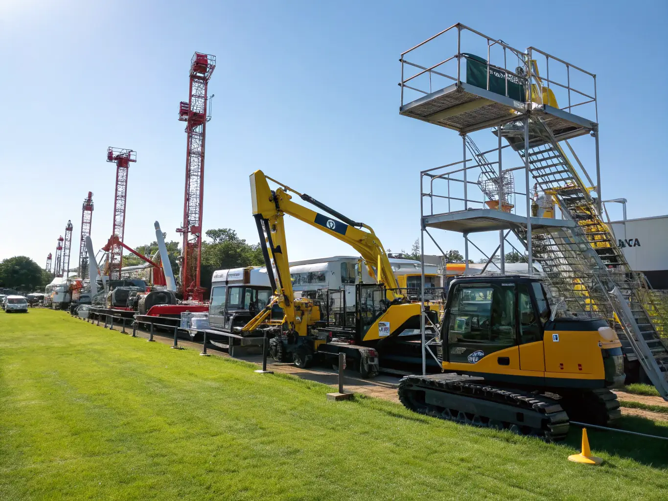 A wide shot of various types of heavy equipment (excavators, loaders, cranes) lined up, all maintained and serviced by RayMechanicals.com, demonstrating the breadth of their capabilities.